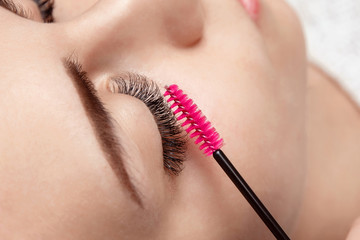 Eyelash extension procedure. Woman with long eyelashes in beauty salon. Lashes close up. Concept spa lash