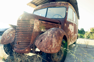 Old rusty bus abandoned at the edge of the road. - obrazy, fototapety, plakaty