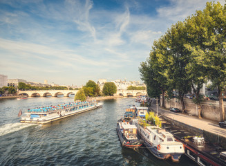 Naklejka premium Picturesque view over la Cite in Paris, France, from the Arts bridge on a summer day with the river Seine and cruise boats. Daytime skyline. Popular travel destination.