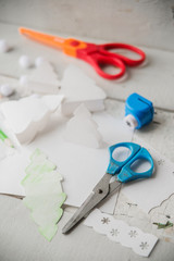 Craft making. Making a greeting card. Colored paper, applique, handmade. Scissors, glue, paint brush. Dark wood background. School supplies