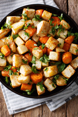 Baked celery root and carrots close-up on a plate. Vertical top view