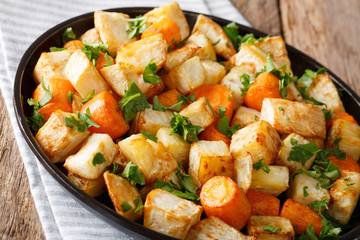 Home-baked celery root and carrots close-up on a plate. horizontal, rustic style