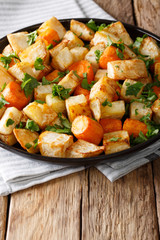 Vegetarian food: baked celery root and carrots close-up on a plate. vertical