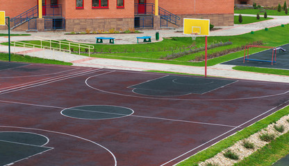 Schoolyard with a playground for basketball. Doing sports at school