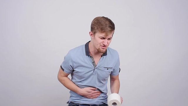 Man having a stomachache on a gray background