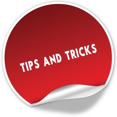 TIPS AND TRICKS text on realistic red sticker on white background.