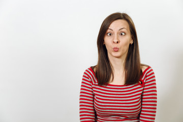Obraz premium Beautiful European young happy brown-haired woman with healthy clean skin and charming smile, dressed in casual red and grey clothes, fooling and laughing on a white background. Emotions concept.