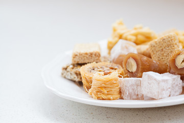 variety of honey oriental sweets in a white plate