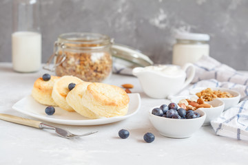 curd cheese cakes and granola with honey, yogurt, sour cream and milk