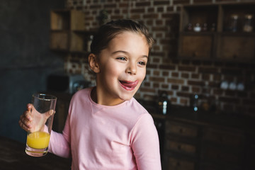 child drinking orange juice