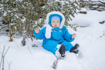 Fototapeta na wymiar A baby sitting in a snow surprising the winter 