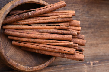 Cinnamon sticks in wooden bowl for background