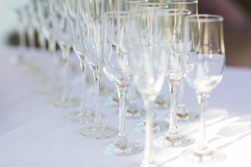 Horizontal photo of aligned empty wine glasses, close up, black and white. Selective focus.