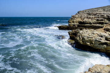 Fototapeta na wymiar waves break against rocks