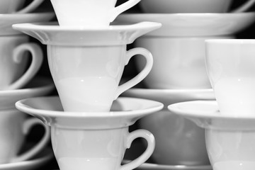 Black and white image of salt and pepper shakers, sugar-bowl and paper napkin holder in the wooden table
