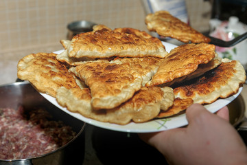 Chebureki are fried in pan. National dish of the Crimean Tatars and traditional for the Caucasian and Turkic peoples