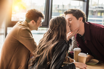 heterosexual couple kissing at cafe