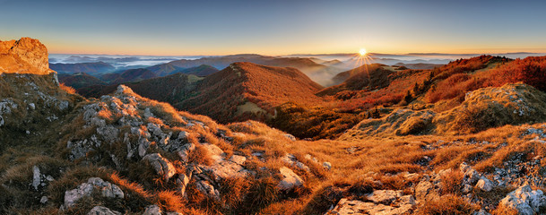 Panorama of sunset in a Carpathian mountain valley with wonderful gold light on a hills