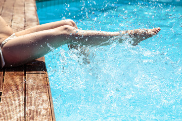 woman's legs over pool water