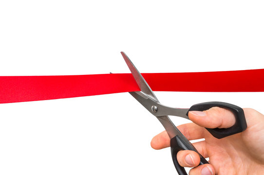 Grand opening ribbon cutting ceremony. Golden scissors cut ribbon