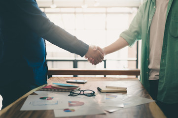 Two hipster shaking hands on meeting