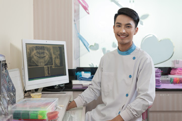 Male dentist crossing armin dental clinic - obrazy, fototapety, plakaty