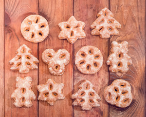 Obraz na płótnie Canvas Festive gingerbreads in the different shapes on wooden planks