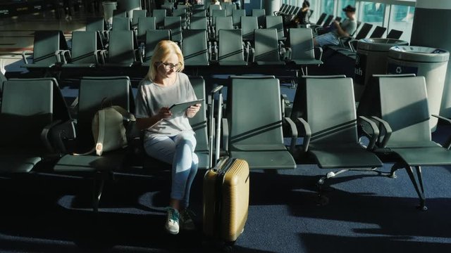 Young woman enjoys a tablet in the airport lounge