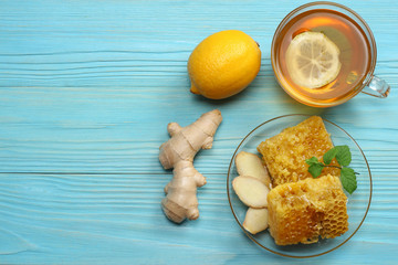 healthy background. honey, honeycomb, lemon, tea, ginger on blue wooden table. Top view with copy space