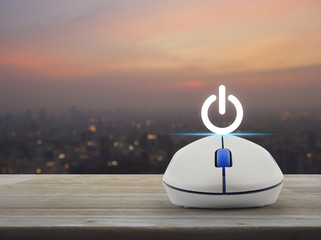 Power button with wireless computer mouse on wooden table over blur of cityscape on warm light sundown, Start up business concept