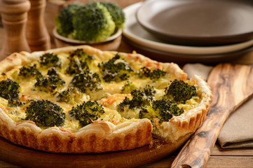 Quiche with broccoli , on wooden background.