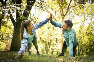 Couple stretching in park. Young couple working exercise together.