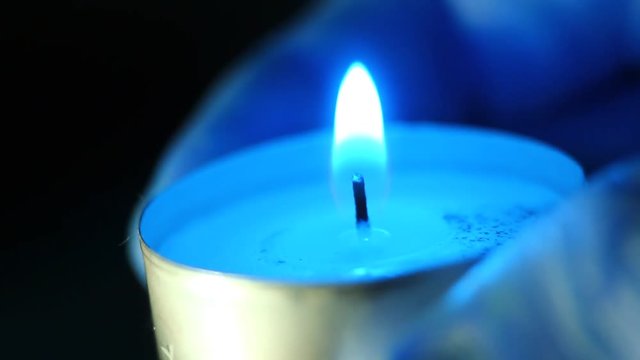 Holding single tea candle in a palm hand macro clip. Extreme macro clip. Little shallow dept of field (DOF).