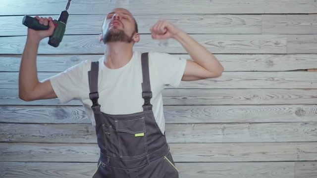 construction worker with a drill in his hand dancing fun