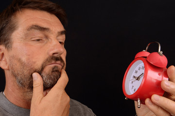 Homme regardant un réveil-matin 