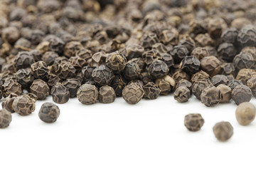 black peppercorns on white background