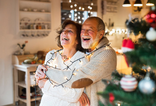 Senior couple hugging at home at Christmas time.
