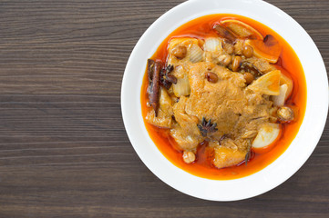 Massaman curry chicken in white bowl on dark wooden background