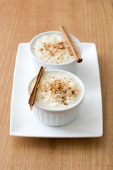 Arroz con leche. Rice pudding with cinnamon on wooden background
