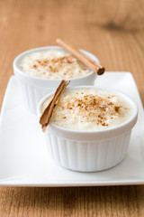 Arroz con leche. Rice pudding with cinnamon on wooden background
