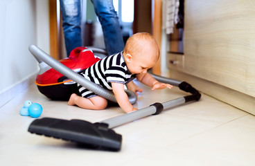 Young mother with a baby boy doing housework.