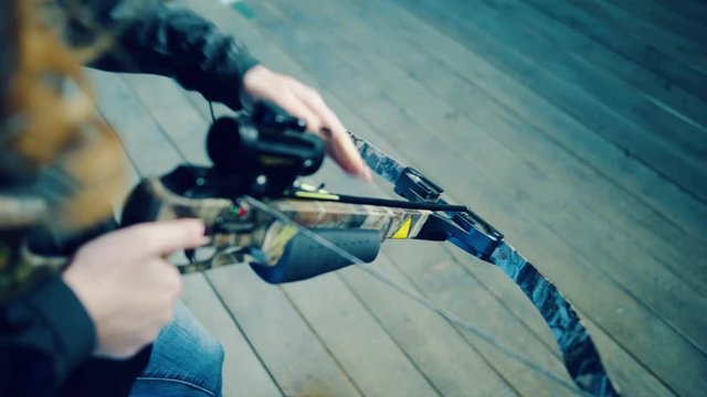 Girl inserts arrow into crossbow