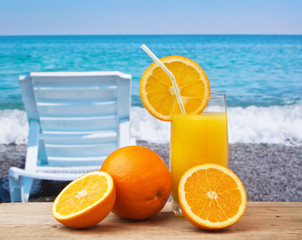 Glass of orange juice on a beach