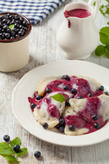 Delicious dumplings with fresh blueberries served with whipped cream and sugar or sauce.