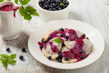 Delicious dumplings with fresh blueberries served with whipped cream and sugar or sauce.