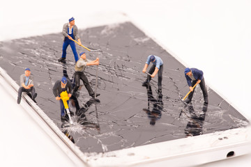 miniature people repair smartphone crack
