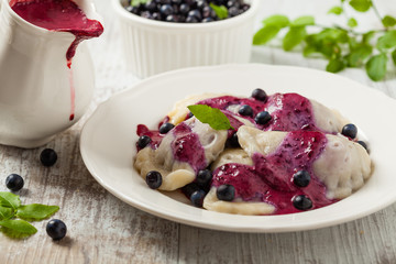 Delicious dumplings with fresh blueberries served with whipped cream and sugar or sauce.