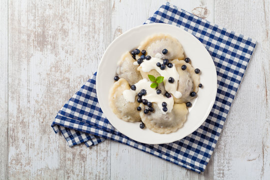 Delicious dumplings with fresh blueberries served with whipped cream and sugar or sauce.