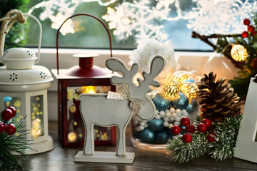 christmas window decoration with wooden reindeer and old lanterns