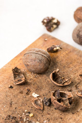 Wooden board and walnuts for cleaning above white marble background table